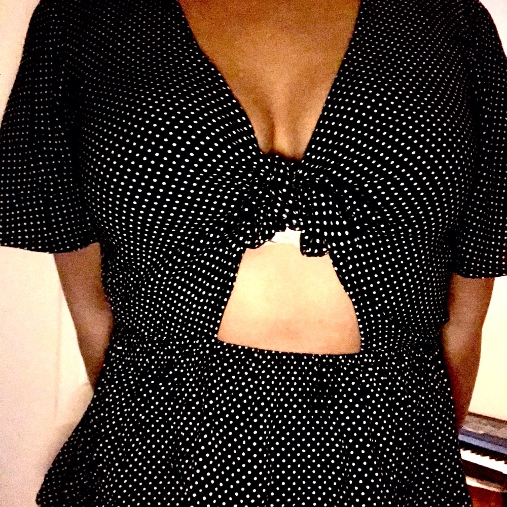 Polka-dotted Peplum with tie closure in front and cutout design; sized medium.